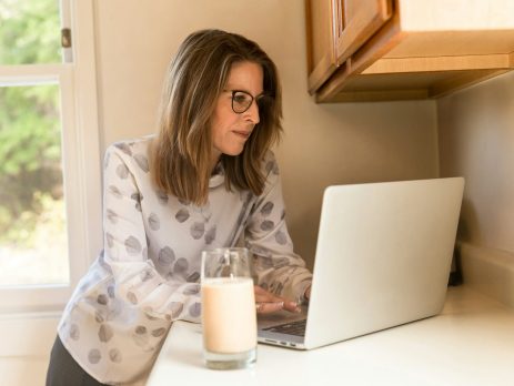 woman using her MacBook Pro inside white room